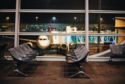 Close-up of chairs on table in city at night