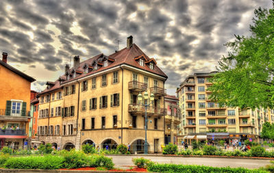 Buildings in city against cloudy sky