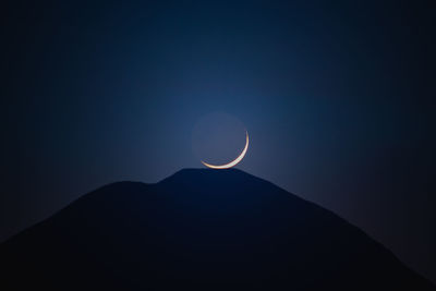 Low angle view of silhouette mountain against sky at night
