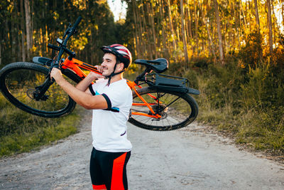 Man carrying bicycle on shoulder