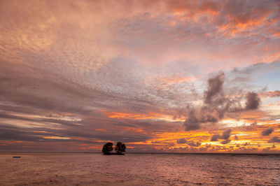 Beautiful tropical sunset over the sea horizon with black silhouette of an island. seychelles