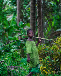 Full length of man standing by tree in forest