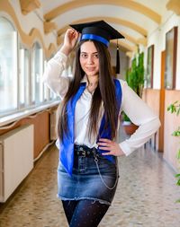 Young woman wearing graduation gown