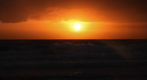 Scenic view of sea against orange sky