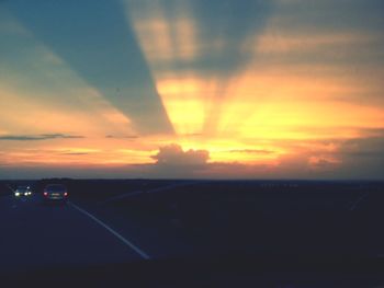 Car on road against sky during sunset