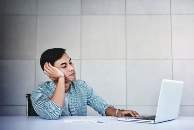 Senior woman using mobile phone while sitting on table