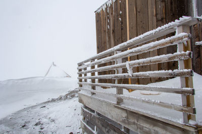 Built structure on snow covered field against sky