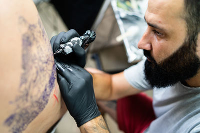 Close-up of artist making tattoo