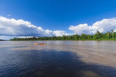 Traditional boat with passengers sailing along the suriname river