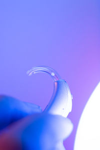 Close-up of hand holding glass against blue background