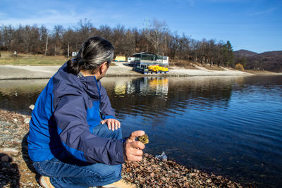 Man throwing a rock in lake