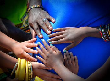 Cropped image of hands touching pregnant woman abdomen