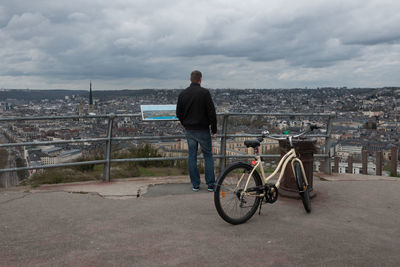 Man with bicycle on road in city