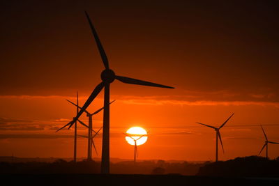 Silhouette of wind turbines at sunset