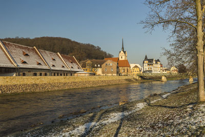 River amidst buildings against clear sky