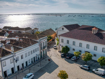 High angle view of houses by sea against sky