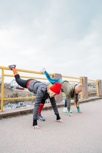 Two young women friends stretches during workout, fit girls exercising 