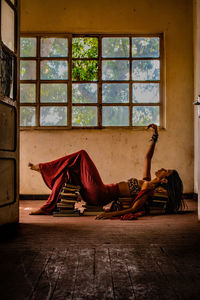 Woman sitting on floor by window