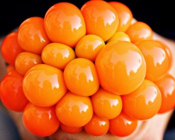 Cropped hand squeezing orange stress ball