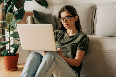 Young female freelancer talking on video call using laptop.