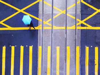 High angle view of person holding umbrella while walking on street