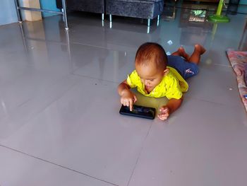 High angle view of cute boy using mobile phone