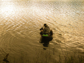 Fisherman on boat in sea during sunset