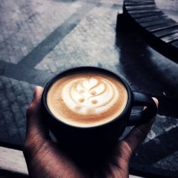 High angle view of hand holding coffee cup