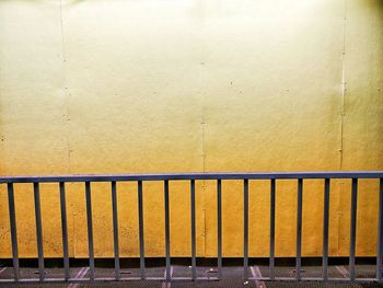 Metal railing against yellow wall