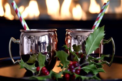 Close-up of christmas drinks on table against fire