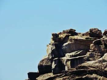 Low angle view of rocks against clear sky