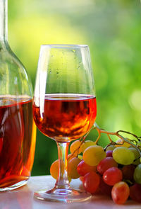 Close-up of red wine and grapes on table