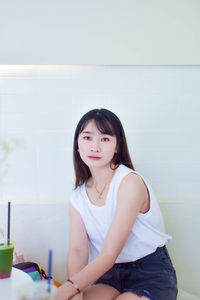 Portrait of young woman sitting at home