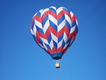 Low angle view of hot air balloon against clear blue sky