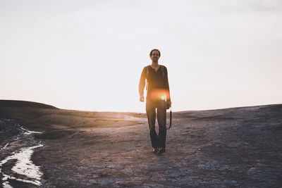 Man walking on desert against clear sky