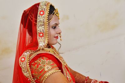 Close-up of bride wearing sari against wall