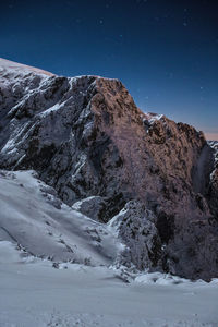 Scenic view of snowcapped mountains against sky at night