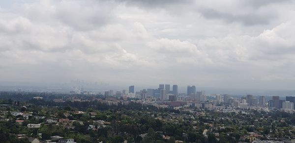 Aerial view of buildings in city against sky