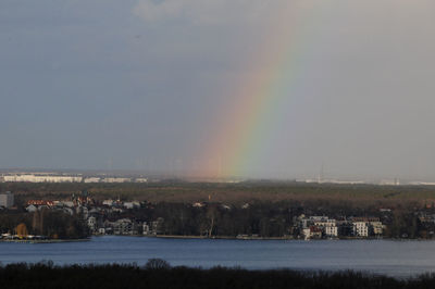 Scenic view of rainbow over lake against sky