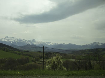 Scenic view of field and mountains against sky