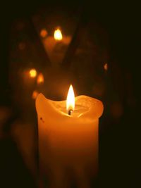 Close-up of lit candle in dark room