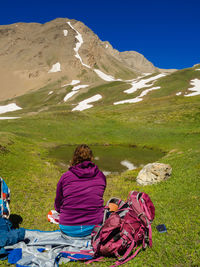 Rear view of woman sitting on landscape