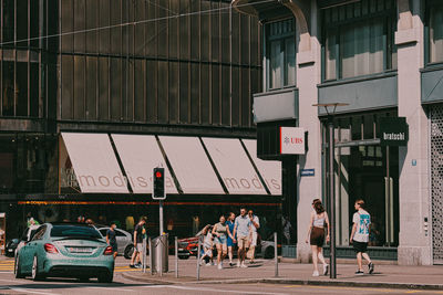 People walking on street against buildings in city