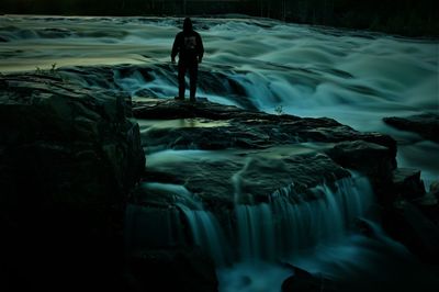 Man standing on rocks by sea