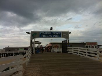 Information sign on railing against sky