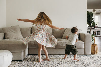 Siblings twirling in living room