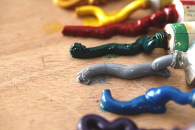 Close-up of multi colored paint tubes on table