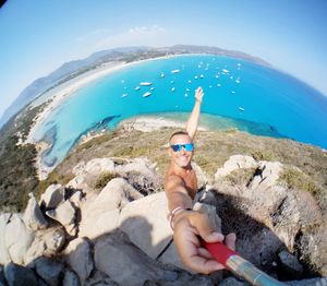 Midsection of shirtless man in sea against clear sky