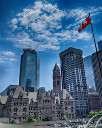 Buildings in city against cloudy sky