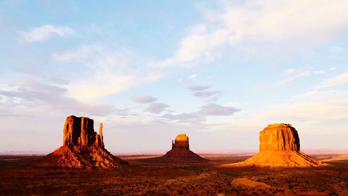 Rock formations on landscape against cloudy sky